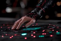 Futuristic cyberpunk hand with black metallic armor touching holographic interface with glowing red and turquoise lights against dark background.