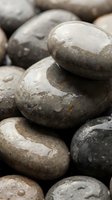Smooth weathered river stones stacked in natural arrangement showcasing organic textures and earth tones for zen meditation spa wellness design concepts.