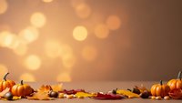 Autumn harvest display with pumpkins, gourds and colorful fall leaves on wooden surface against warm bokeh background for seasonal decorating and thanksgiving.