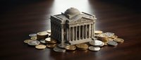Miniature bank building model surrounded by golden coins on wooden surface representing financial institution, savings, investment and monetary concepts.