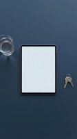 Tablet with blank white screen on dark blue desk, flat lay with glass of water and keys, mockup for app or web design.