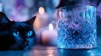 Black cat with bright blue eyes next to crystal glass and glowing candles in mystical blue lighting, creating magical atmospheric mood for spiritual and wellness concepts.