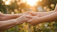 Elderly and young hands holding together in warm golden sunlight, symbolizing intergenerational connection, family bonds, care and support between generations.