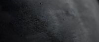 Dark textured surface with fine dust particles and subtle grain, suitable for backgrounds, overlays, and design elements.