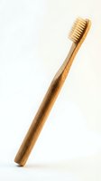 Eco-friendly bamboo toothbrush with natural bristles isolated on white background for sustainable dental care and zero waste lifestyle.