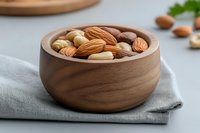 Mixed nuts in wooden bowl on linen napkin featuring almonds, walnuts and cashews for healthy snacking and cooking ingredients.