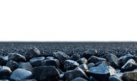 Dark stones and pebbles scattered on white surface creating natural textured background with selective focus and shallow depth of field for spa and wellness designs.