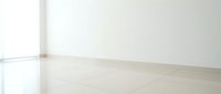 Empty white room interior with glossy marble floor and natural window light creating minimalist modern space for product placement and design mockups.