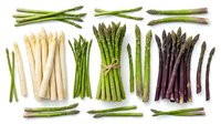 Assorted fresh asparagus varieties including green, white, and purple spears arranged on white background, suitable for culinary, food styling, and recipe design projects.