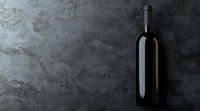 Dark wine bottle against textured concrete wall in moody lighting creates dramatic atmosphere for wine marketing, restaurant menus, and beverage promotions.