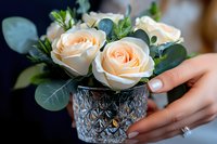 Elegant peach roses arrangement in decorative crystal vase with eucalyptus leaves for wedding centerpiece or romantic home decor.