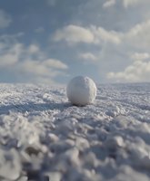 Single snowball on fresh snow surface against cloudy winter sky, close-up view with shallow depth of field creating dreamy atmosphere.