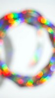 Blurred colorful bokeh lights forming circular frame on white background for festive holiday decorations and celebration designs.