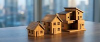 Wooden house models arranged in ascending size on desk representing real estate growth, property investment, mortgage planning, and housing market development concept.