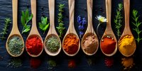 Colorful aromatic spices and herbs in wooden spoons arranged in row on dark background, perfect for cooking, food blog, or restaurant menu design background.