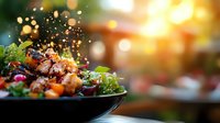 Fresh grilled shrimp salad with mixed greens and citrus dressing in dark bowl against blurred warm bokeh background, close up view with water droplets.