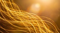 Abstract golden light trails flowing in dynamic waves against warm amber background for modern digital design and technology concepts.