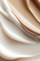 Smooth flowing curves in cream and white create elegant abstract background with soft satin texture and gentle wave-like movement. Suitable for luxury branding.