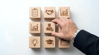 Business professional selecting wooden cube with key icon from collection of corporate symbols representing success and growth strategies.