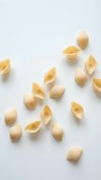 Scattered conchiglioni pasta shells arranged on white background, isolated and ready for food, cooking, and culinary design projects.