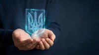 Businessman holding glowing holographic Ukrainian trident symbol in palm against dark background, representing national identity, patriotism, and digital technology innovation.