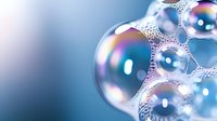 Colorful soap bubbles floating with rainbow reflections and iridescent surface textures against soft blue gradient background for cleaning concepts.