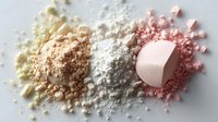 Colorful crushed makeup powder piles in yellow, beige, white and pink shades with round compact on light background, cosmetic product photography.