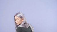 Woman with long silver hair looking downward against lavender background, suitable for beauty, aging gracefully, and hair care marketing campaigns.