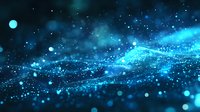 Glowing blue particles flow in waves against dark background creating magical atmosphere with bokeh light effects and sparkles in motion.