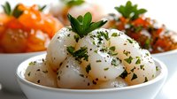 Boiled potatoes with fresh herbs and black pepper seasoning served in white bowl, healthy side dish for lunch or dinner meals.