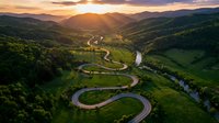 Aerial view of winding river flowing through lush green valley with forested hills at golden hour sunset, scenic landscape for travel and nature projects.