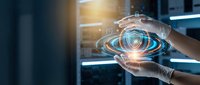 Hands holding glowing digital eye hologram with data network visualization in modern server room environment for technology and cybersecurity concepts.