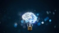 Creative lightbulb with glowing brain inside representing innovation, intelligence and bright ideas on dark blue bokeh background for business concepts.
