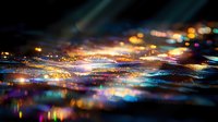 Colorful bokeh lights reflecting on water surface create magical nighttime atmosphere with blurred glowing spots in blue, gold and purple hues.