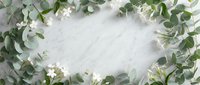 Elegant eucalyptus and white flower frame on marble background for wedding invitations, greeting cards and botanical design projects.
