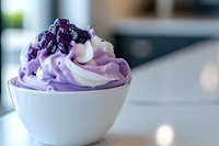 Creamy purple frozen yogurt swirled with vanilla in white ceramic bowl, topped with fresh blackberries and blueberries. Refreshing summer dessert for healthy lifestyle.
