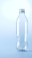 Empty clear plastic water bottle isolated on light blue background for recycling and environmental concepts.