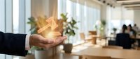 Professional hand holding glowing golden trophy in modern office environment symbolizing business achievement and corporate success recognition.
