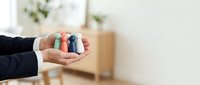 Person holding colorful asthma inhalers in cupped hands showing respiratory medication management and breathing treatment options for healthcare.