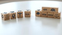 Wooden blocks with motivational words and symbols arranged on white surface for personal development and mindfulness concepts.