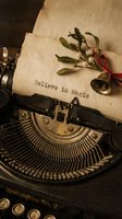 Vintage typewriter with aged paper typed Believe in Magic, decorated with mistletoe and a small bell, evoking nostalgic holiday charm.
