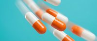Orange and white pharmaceutical capsules scattered on turquoise background for medical healthcare and medication concepts in modern clean style.