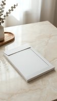 White envelope mockup on marble table with eucalyptus decor, minimal aesthetic, soft natural light for branding and stationery design.