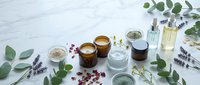 Natural skincare cosmetics with eucalyptus leaves and lavender flowers on marble background. Organic beauty products, essential oils and botanical ingredients.