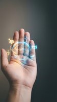 Hand holding glowing globe with renewable energy icons including solar panels and wind turbines, representing sustainable technology and green power solutions.