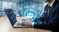 Professional businessman using laptop with digital customer relationship management interface displaying team icons and communication symbols in modern office environment.