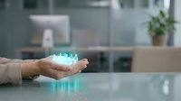 Professional businesswoman holding glowing digital crown hologram in modern office environment representing leadership success and corporate achievement.
