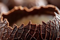 Extreme close up of dark chocolate bark with textured surface showing intricate patterns and cracks, rich brown tones and selective focus for food photography.