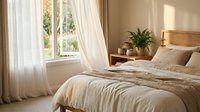 Cozy bedroom interior with natural light streaming through white curtains, wooden headboard, neutral bedding and green plant creating peaceful atmosphere.