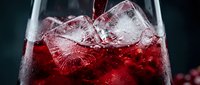 Red cocktail being poured into a glass with ice cubes, vibrant crimson drink splashing over frozen chunks, dark moody background for bar menu.